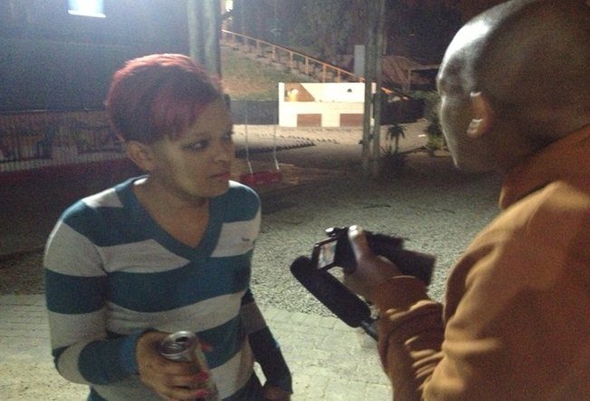 Researcher interviewing a woman on camera at night